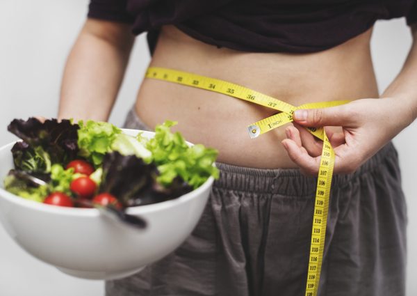 Woman measuring her tummy and weight